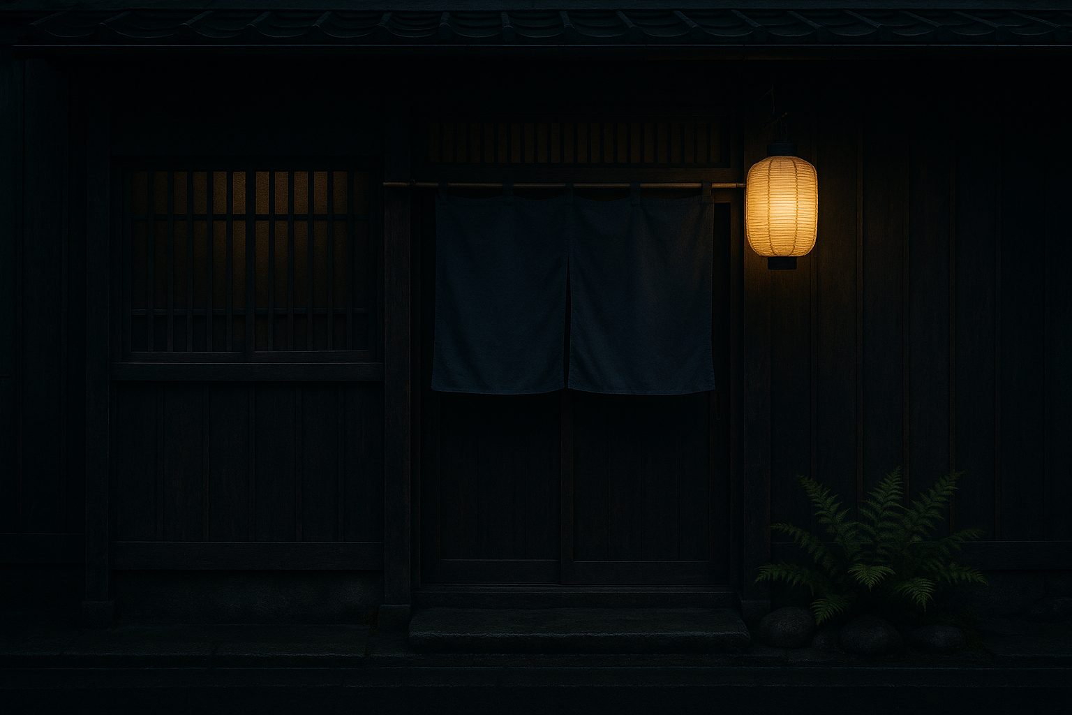 夕暮れの穂澄の店構え。藍色の暖簾と提灯